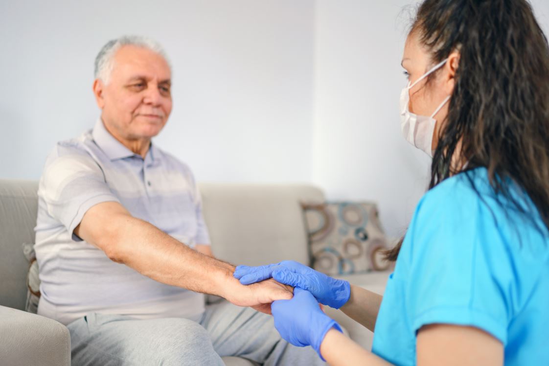 Nurse holding man's hand