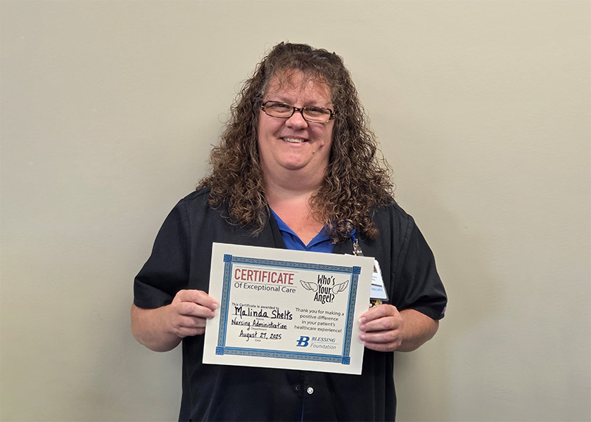 Malinda Shelts showing her award