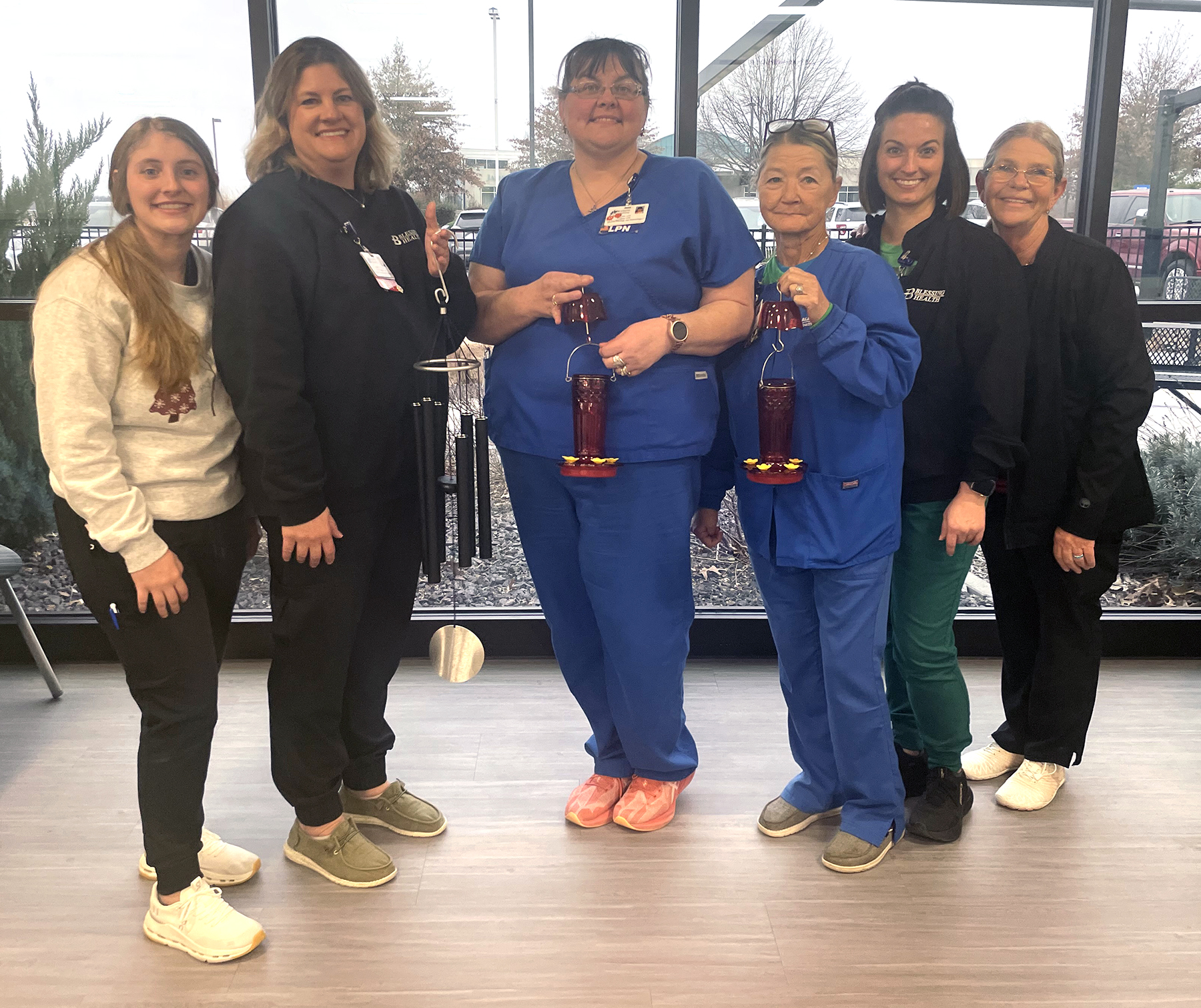 Blessing Health Hannibal Cancer Center team members displaying the wind chime and hummingbird feeders